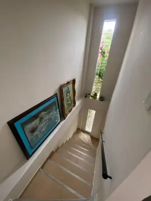 a stairway with two paintings and a window at Northwest Hostings 4 in Cartagena de Indias