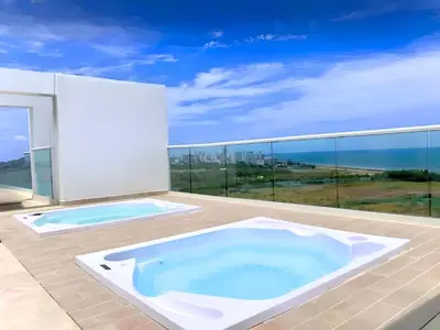 a hot tub on a balcony with a view of the ocean at Dominique Luxury - 1 BR - Private Jacuzzi - 13th Floor in Cartagena de Indias