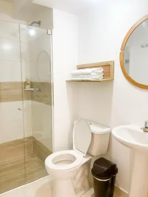 a bathroom with a toilet and a glass shower at Comfortable and central apartment in Bquilla in Barranquilla