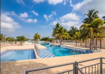 a pool at the resort with palm trees at Apto De 3 Hab con Vista y Salida directa Al Mar in Estación El Salto