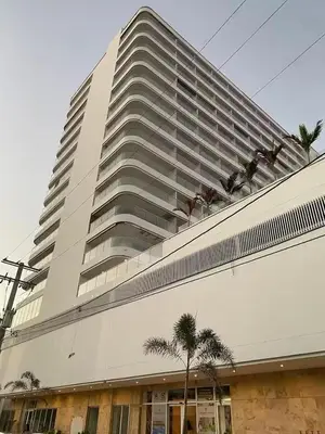 a large building with palm trees in front of it at Apartasuite en Cartagena in Cartagena de Indias