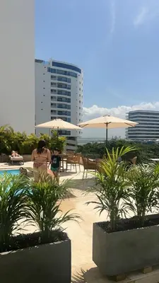 a pool with umbrellas and tables and chairs at Apartasuite en Cartagena in Cartagena de Indias