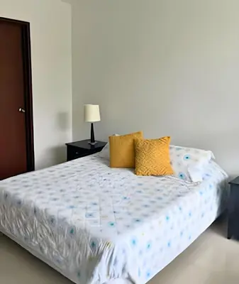 a bedroom with a bed with a blue and white comforter at Beachfront Paradise with Pools and Spa in Cartagena de Indias