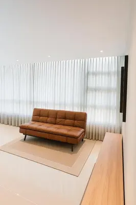 a brown couch sitting in front of a window at Apto Grand- Ithiel in Barranquilla