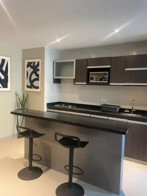 a kitchen with a counter and two stools in it at Apto Grand- Ithiel in Barranquilla