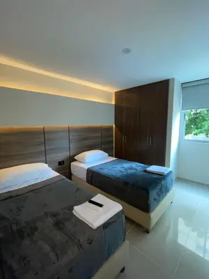a bedroom with two beds and a window at Apto Grand- Ithiel in Barranquilla