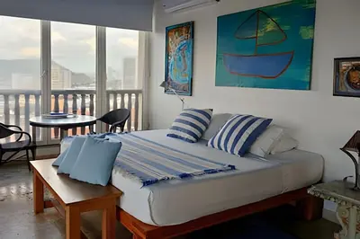 a bedroom with a bed and a balcony with a table at Amplio apartamento en Ciudad Amurallada, vista impresionante in Cartagena de Indias