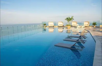 a swimming pool with chairs and the ocean in the background at Apartamento en la Boquilla, Cartagena in Cartagena de Indias