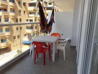 a white table and chairs and an umbrella on a balcony at Apartamento en la Boquilla, Cartagena in Cartagena de Indias