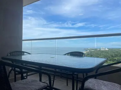 a table on a balcony with a view of the ocean at Apto Lujo Vista Mar Piscina AC WIFI Playa a 3 min en Santa Marina in Santa Marta