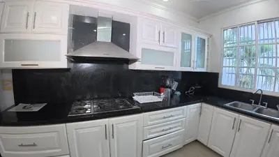 a kitchen with white cabinets and a stove top oven at Casa cerca al mar Zona Norte Cielo Mar Cartagena in Cartagena de Indias
