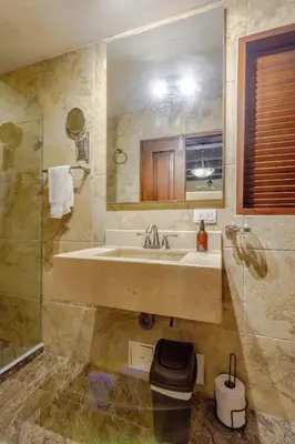 a bathroom with a sink and a mirror and a shower at Estrella de San Pedro B&B in Cartagena de Indias