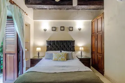 a bedroom with a large bed with a black headboard at Estrella de San Pedro B&B in Cartagena de Indias