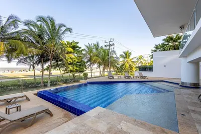 an indoor swimming pool with a view of the beach at Luxurious Beachfront 3BR, Pool & Ocean Views in Cartagena de Indias