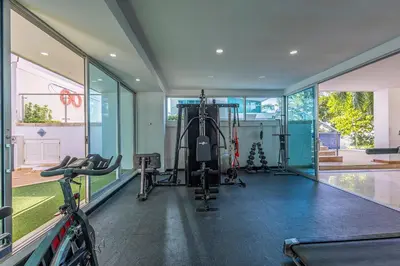 a gym with treadmills and equipment in a house at Luxurious Beachfront 3BR, Pool & Ocean Views in Cartagena de Indias