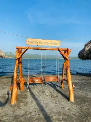 a wooden swing on the beach near the water at Cabaña frente al mar in Tubará