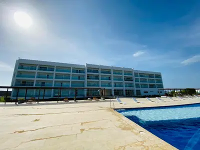 a building with lounge chairs in front of a pool at Cabaña frente al mar in Tubará