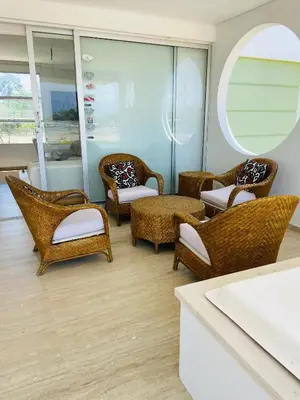 a room with wicker chairs and tables and a mirror at Cabaña frente al mar in Tubará