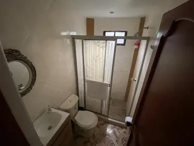 a small bathroom with a toilet and a shower at Posada Encanto Cartagena in Cartagena de Indias