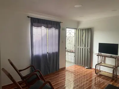 a living room with a window and a television at Posada Encanto Cartagena in Cartagena de Indias