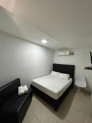 a small bedroom with a bed and a couch at Lago Hotel Cartagena in Estación El Salto