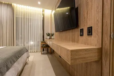 a bedroom with a bed and a television on a wall at Luxury Oasis Private Pool Wine BBQ and Sea in Cartagena de Indias