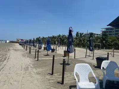 a row of umbrellas and chairs on the beach at Cartagena Serena del mar Morros IO in Cartagena de Indias