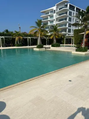 a swimming pool with palm trees and a building at Cartagena Serena del mar Morros IO in Cartagena de Indias