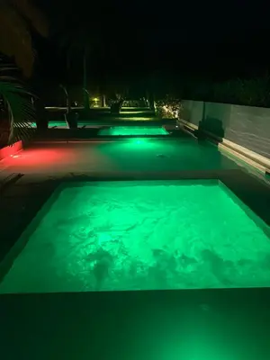 a swimming pool lit up at night with green lights at Cartagena Serena del mar Morros IO in Cartagena de Indias