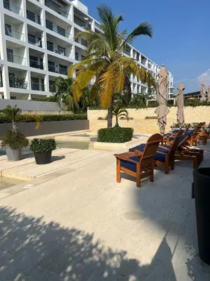 a row of lounge chairs on the beach near a hotel at Cartagena Serena del mar Morros IO in Cartagena de Indias