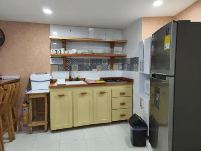 a kitchen with yellow cabinets and a refrigerator at Apartamento con vista al Laguito, Nuevo Conquistador in Cartagena de Indias