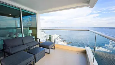 a balcony with a couch and a view of the water at Oceanview Suite with two Pools, Gym & Guest Access in Cartagena de Indias