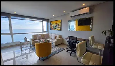 a living room with a couch and a table at Oceanview Suite with two Pools, Gym & Guest Access in Cartagena de Indias