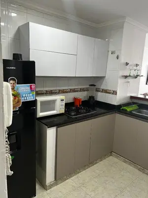 a kitchen with white cabinets and a black refrigerator at Cristoforo Colombo CARTAGENA