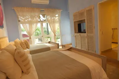 a bedroom with two beds and a large window at Hotel casa santiago botero in Cartagena de Indias