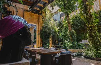 an outdoor patio with a wooden table and plants at Hotel casa santiago botero in Cartagena de Indias