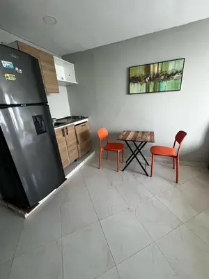 a kitchen with a refrigerator and two chairs and a table at ApartaEstudio cerca a Bocagrande in Cartagena de Indias