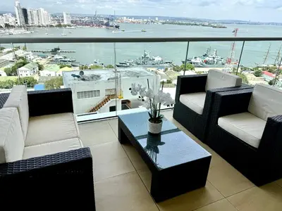 a balcony with chairs and a table and a view of the water at Moderno Apartamento 1504 in Cartagena de Indias