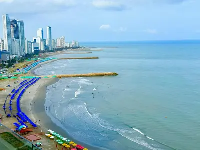a beach with umbrellas and crowds of people and buildings at Moderno Apartamento 1504 in Cartagena de Indias