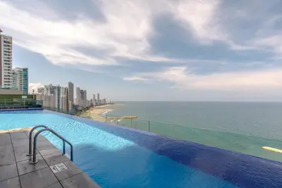 a swimming pool on top of a building next to the ocean at Moderno Apartamento 1504 in Cartagena de Indias