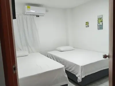 two beds in a room with white walls at Casa 19 in Ciénaga