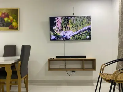 a living room with a table and a painting on the wall at Apartamento Alameda del Rio in Barranquilla