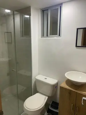 a bathroom with a toilet and a glass shower at Apartamento Alameda del Rio in Barranquilla