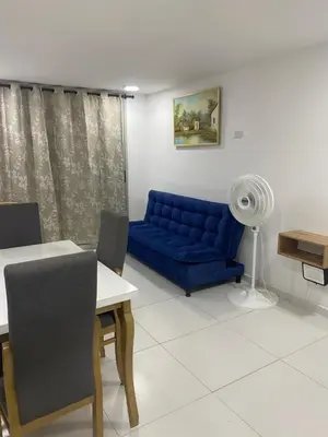 a living room with a blue couch and a table at Apartamento Alameda del Rio in Barranquilla