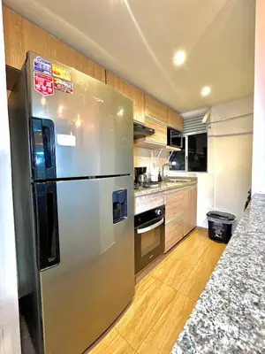 a kitchen with a stainless steel refrigerator and wooden cabinets at Luxury Apartament With Pool in Barranquilla