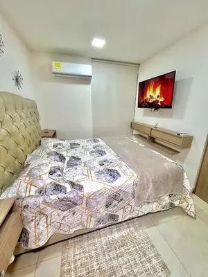 a bedroom with a bed and a tv on the wall at Luxury Apartament With Pool in Barranquilla