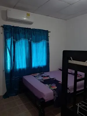 a bedroom with a purple bed and a blue curtain at Hospedaje Mango y Mar Apartamento in Coveñas
