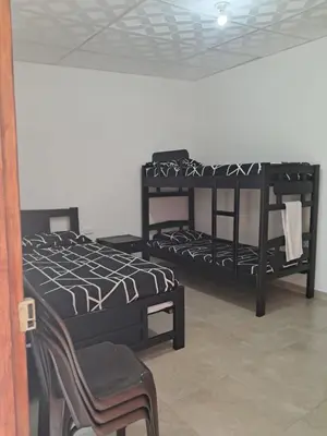 two bunk beds in a room with a chair at Hospedaje Mango y Mar Habitaciones in Coveñas