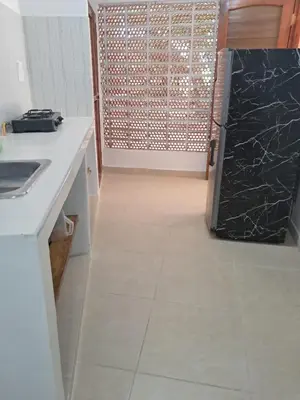 a kitchen with a black refrigerator and a tile floor at Hospedaje Mango y Mar Habitaciones in Coveñas