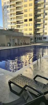 a swimming pool with a bench next to some buildings at Apartamento Plazuela Portal Del Prado in Barranquilla